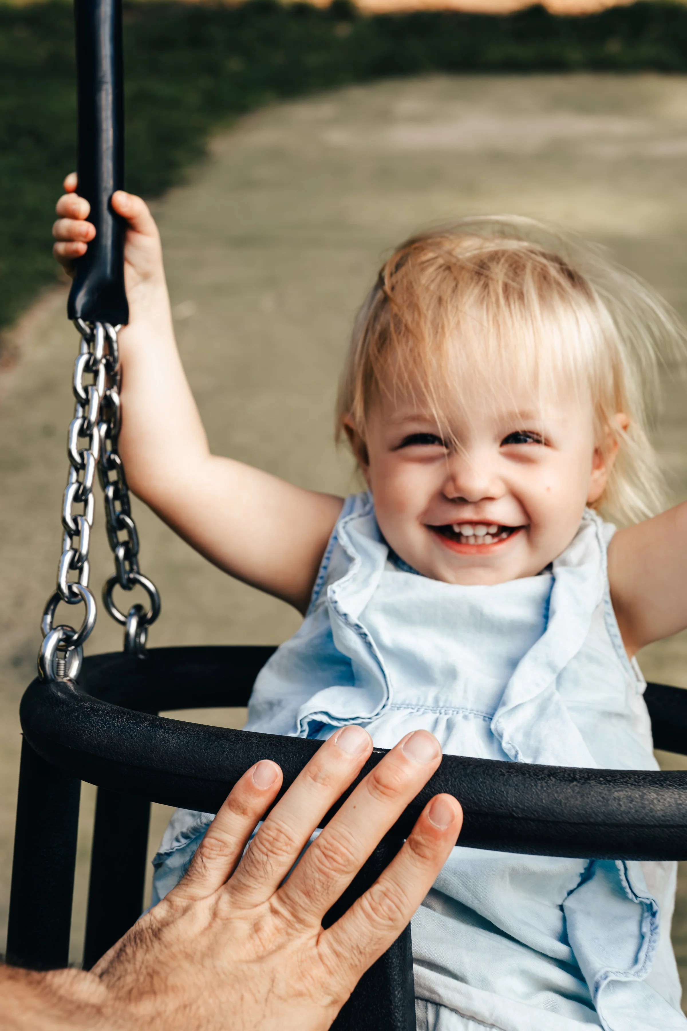 A smiling toddler on a swing