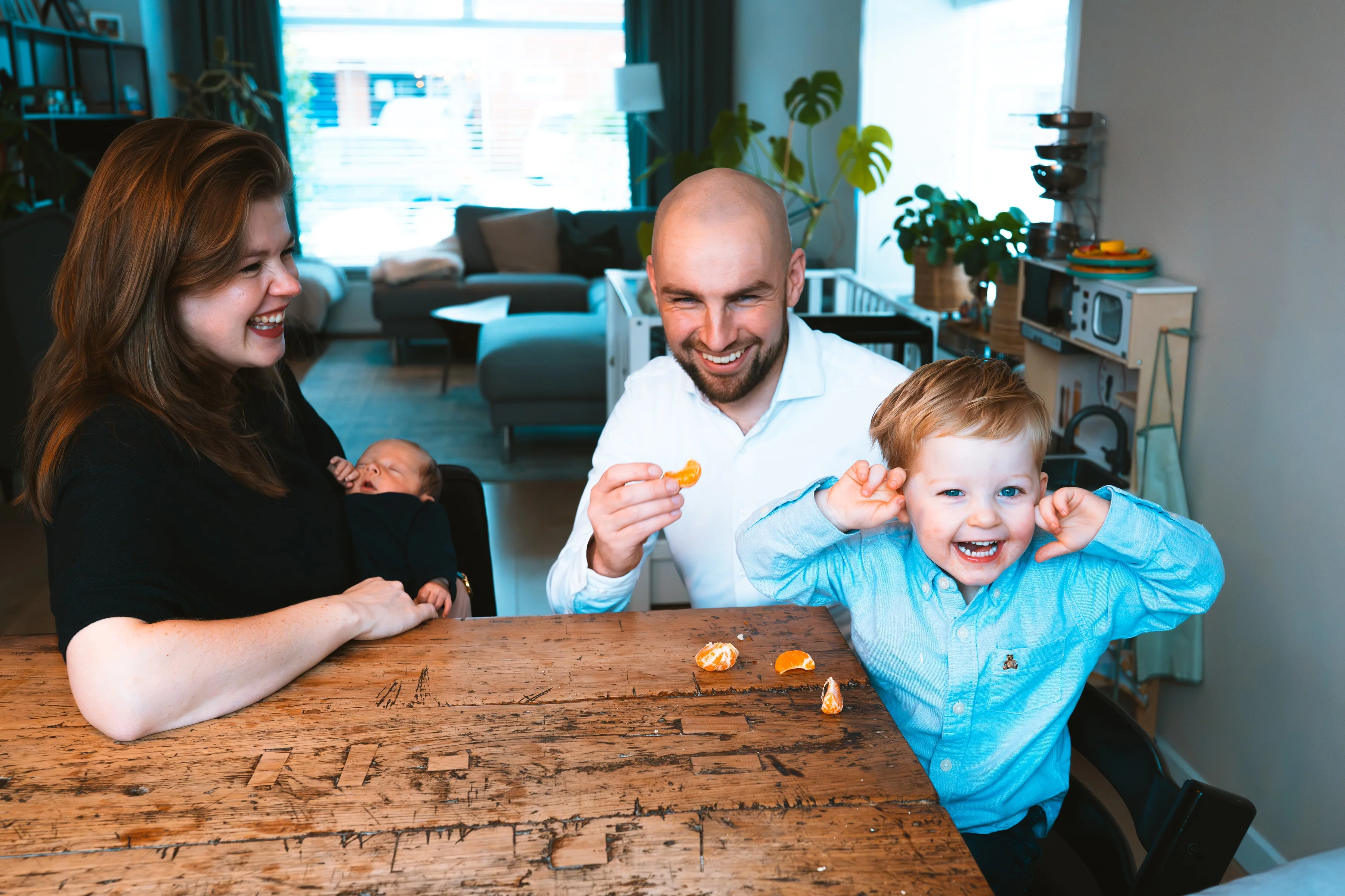 A family laughing together at the kitchen table