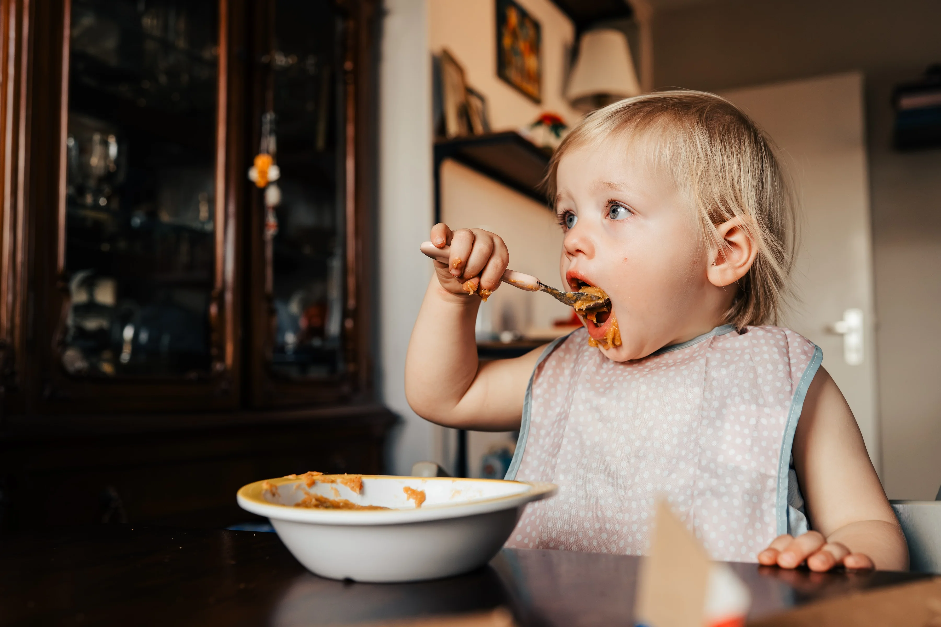 A toddler eating at the table